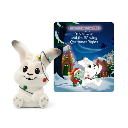 White rabbit figurine beside an Advent Calendar and Christmas lights